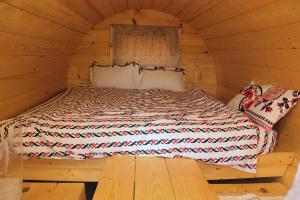 a bedroom with a bed in a wooden cabin at Butoiașele Montesanto - Explora y Alegrate in Copalnic Mănăştur +28 photos