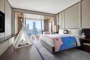 JW Marriott Marquis Hotel Shanghai Pudong في شانغهاي: غرفة نوم بسرير وخيمة لعب