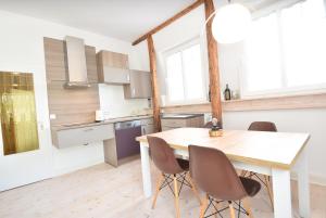 a kitchen with a wooden table and chairs at fewo1846 - Am Walfischstein - strandnahe 2-Zimmer-Wohnung im 1 OG in eleganter Jugendstilvilla in Westerholz