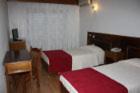 a room with two beds and a table at Hotel Classis in Bragança