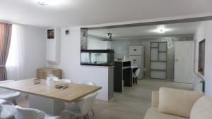 a living room with a dining table and a kitchen at Casuta din drumul muntelui in Drăguş