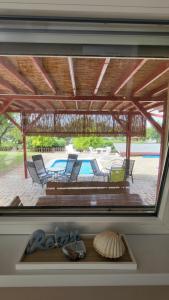 ventana en una habitación con sillas y piscina en Lake Resort, en Sárkeresztes