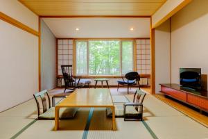 um quarto com uma mesa e cadeiras e uma janela em Kyukamura Nikko-Yumoto em Nikko