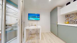 Televízia a/alebo spoločenská miestnosť v ubytovaní Appartements modernes avec véranda