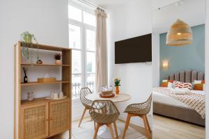 een woonkamer met een bed en een tafel en stoelen bij Studio centre cannes in Cannes