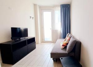 sala de estar con sofá y TV de pantalla plana en Flora Marina_ Appartamento fronte mare, en Porto San Giorgio