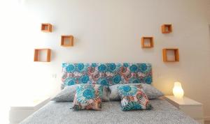 1 dormitorio con 1 cama con cabecero azul y almohadas en Flora Marina_ Appartamento fronte mare, en Porto San Giorgio