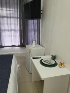 a small white kitchen with a table with a plate on it at Pro Delux inn in Durban