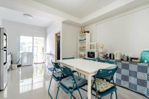 a kitchen with a white table and blue chairs at Turtle Rooms in Bang Tao Beach