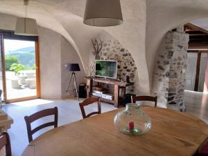 a dining room with a table and a television at Maison de campagne in Mens