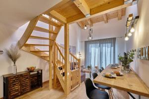 a room with a wooden staircase and a table and chairs at Charming and quiet apartment in Lipno nad Vltavou