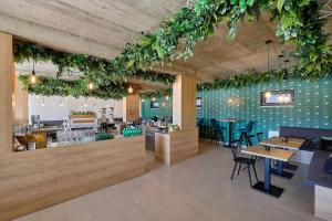 a restaurant with tables and chairs and plants on the wall at Charming and quiet apartment in Lipno nad Vltavou