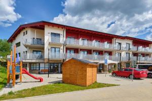 a apartment building with a playground in front of it at Charming and quiet apartment in Lipno nad Vltavou