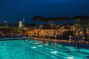 een groep mensen in een zwembad 's nachts bij Camping Village Riva Blu in Padenghe sul Garda