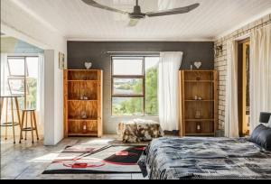 a bedroom with a bed and some windows at Visvanger self catering in Britannia Bay