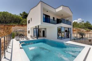 Villa con piscina frente a una casa en Luxury villa Verbenico Hills- amazing sea view, pool with whirpool and waterfall, beach, in famous wine region - Your holiday with style, en Vrbnik