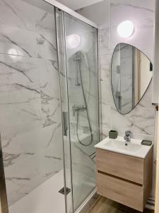 a bathroom with a shower and a sink and a mirror at Plage Cabourg 7 Vue Mer in Cabourg