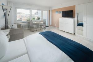 um quarto com uma cama e uma sala de estar em Haus Dünenrose - Dünnenest em Norderney