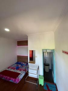 KalakにあるPlatar Ombo Homestayのベッドと椅子のある寝室