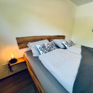 a bedroom with a bed with white sheets and pillows at Naturstrand Apartment - 86m² - 4 Betten - Parkplatz in Hagermarsch