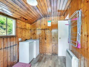 a laundry room with wooden walls and a refrigerator at Meall Darroch in Inverey