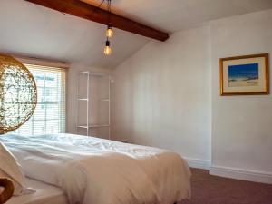 a bedroom with a white bed and a window at Waterloo Sunset in Bootle