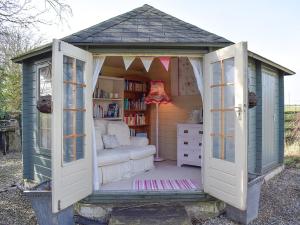 ein kleiner Schuppen mit einem Bett und einem Bücherregal in der Unterkunft Seventh Heaven in Bagby