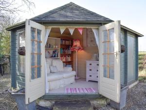 a small shed with a bed and a book shelf at Seventh Heaven in Bagby
