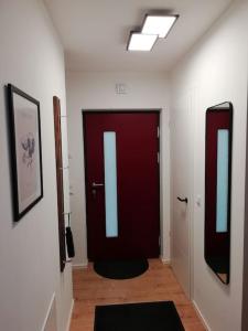 a hallway with a red door and two mirrors at Premium Apartment mit Terrasse in Wörth