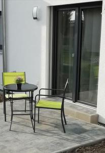 une table et des chaises assises à côté d'une fenêtre dans l'établissement Premium Apartment mit Terrasse, à Wörth