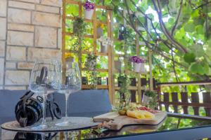 una mesa con dos copas de vino y fruta. en Casa Kiwi en Premantura