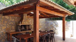 einen Holztisch und Stühle unter einer hölzernen Pergola in der Unterkunft Villa Korakades in Korakádes