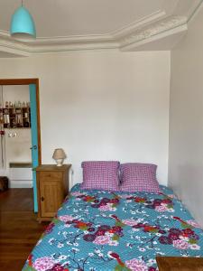 ein Schlafzimmer mit einem Bett mit einer bunten Bettdecke in der Unterkunft Appartement à Montmartre in Paris