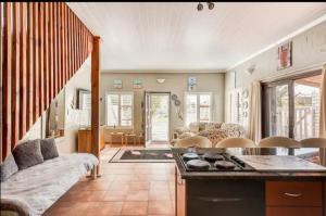 a kitchen and living room with a stove and a couch at Visvanger self catering in Britannia Bay