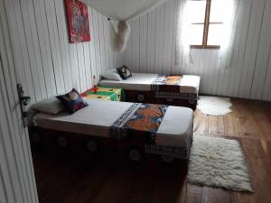 two twin beds in a room with a wooden floor at Hostel Sao Gabriel in São Tomé