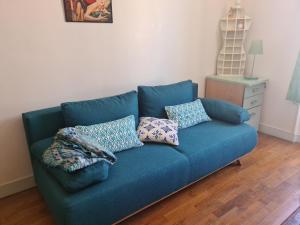 eine blaue Couch in einem Wohnzimmer mit Kissen darauf in der Unterkunft Appartement à Montmartre in Paris