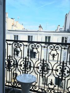 einen Balkon mit einem Tisch auf einem schmiedeeisernen Zaun in der Unterkunft Appartement à Montmartre in Paris