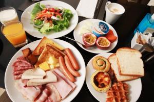 uma mesa com quatro pratos de comida para o pequeno almoço em Grande Centre Point Hotel Terminal21 em Bangkok