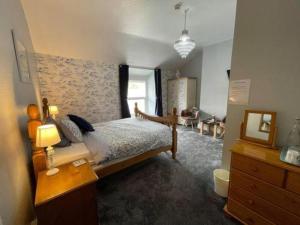a bedroom with a bed and a desk with a mirror at Seascape in Barmouth