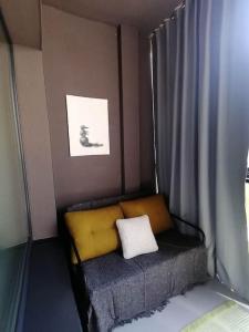 un piccolo letto con cuscino giallo in una stanza di Erdvi studija Spacious studio apartment Self check in a Vilnius