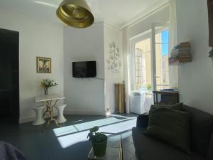 - un salon avec un canapé et une télévision dans l'établissement Un Appart en Ville, à Nice