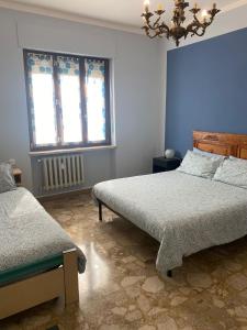 um quarto com 2 camas, um lustre e 2 janelas em Casa ad Alba em Alba