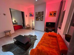ein Wohnzimmer mit rosa Wänden, einem Sofa und einem Tisch in der Unterkunft Antwerp City apartment 2 in Antwerpen