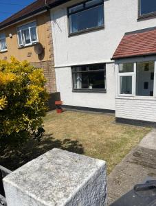 a house with a stone bench in the yard at Blackpool Holiday Home - Forshaw House in Blackpool