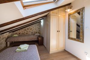 ein kleines Schlafzimmer mit einem Bett und einem Spiegel in der Unterkunft Stone House in Ražanac