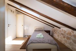 ein Schlafzimmer mit einem Bett im Dachgeschoss in der Unterkunft Stone House in Ražanac