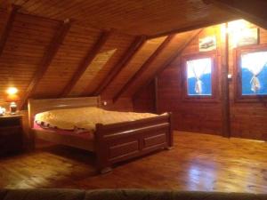 a bed in a wooden room with two windows at Top of the hill - Paradise in Ulcinj