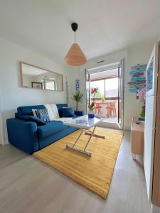 sala de estar con sofá azul y mesa en Plage Cabourg 7 Vue Mer, en Cabourg