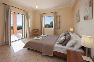 a bedroom with a large bed and a balcony at Villa Kyma, Kaminaki Villas in Corfu With Private Pool And Spectacular Sea Views in Agní