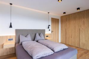 - une chambre avec un grand lit et des oreillers blancs dans l'établissement Beim Lackl, à Avelengo
